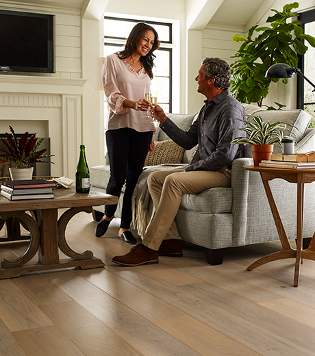 Couple in living room with wood-look luxury vinyl flooring from Carpet Plus in the Worthington, MN area