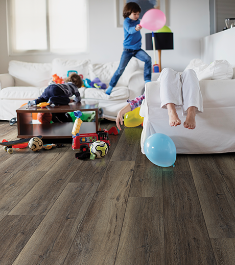 Kids playing in living room with wood-look luxury vinyl flooring from Carpet Plus in the Worthington, MN area