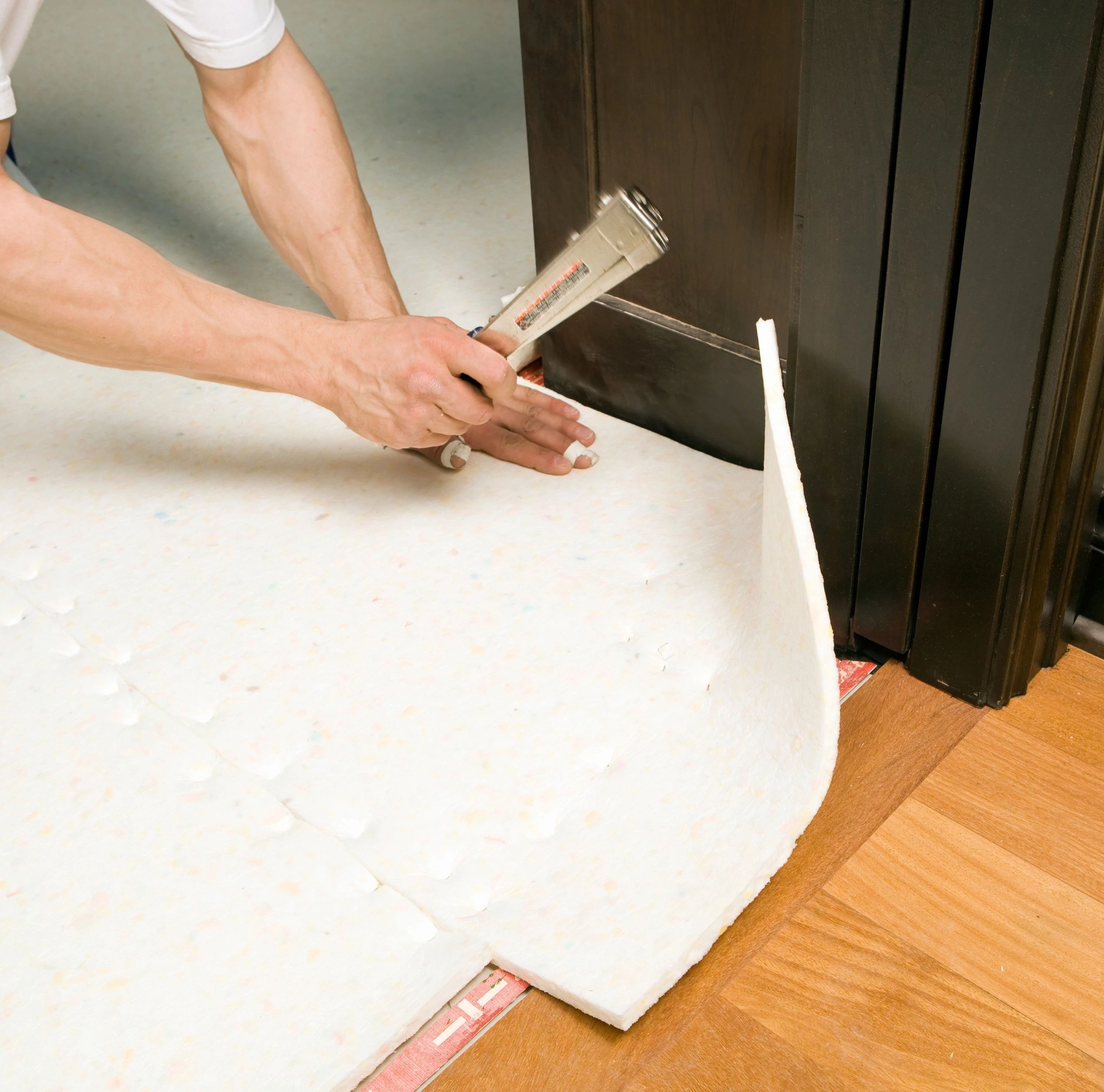 person installing flooring underlayment from Carpet Plus in the Worthington, MN area